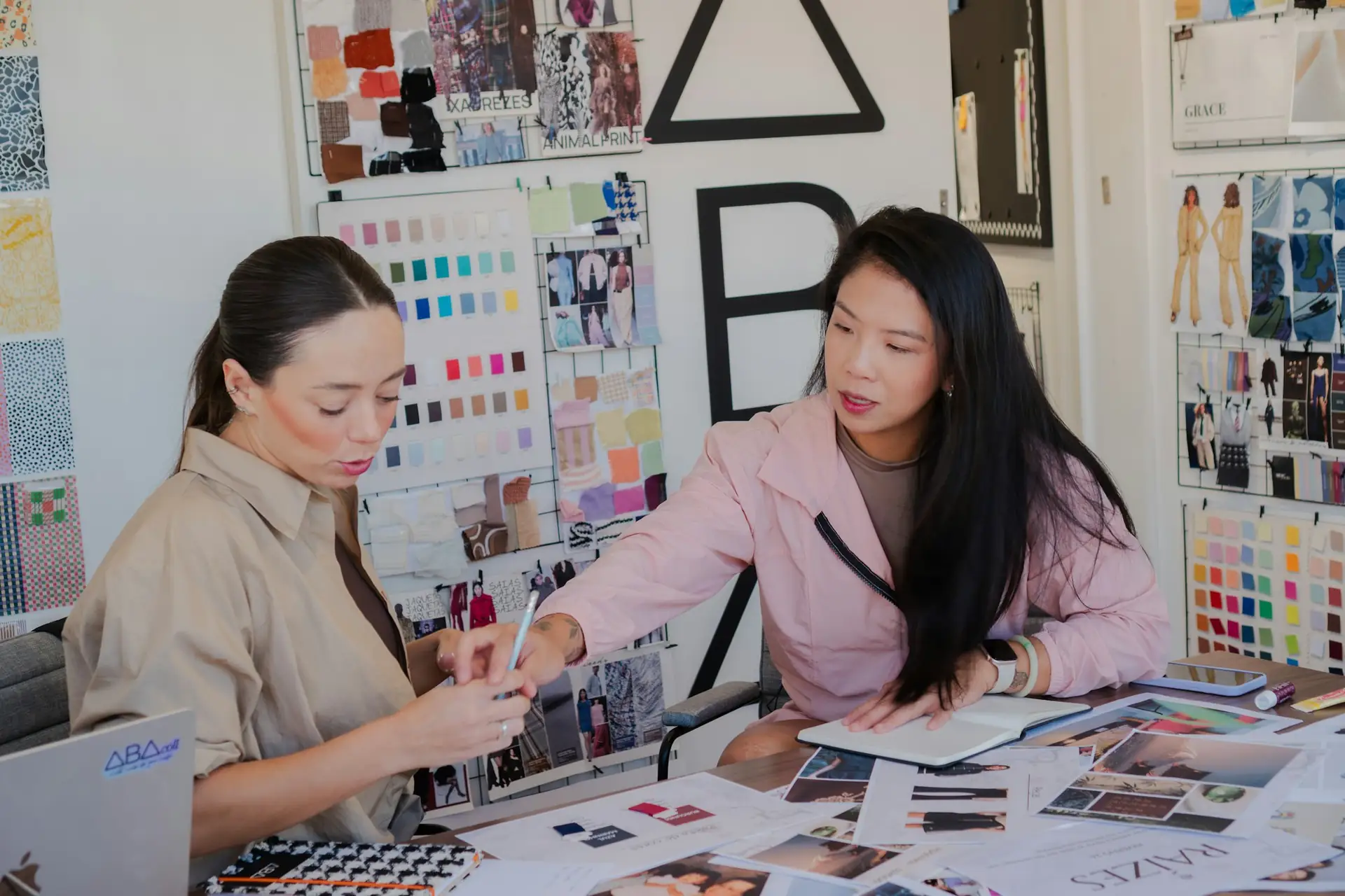 Two designers comparing colour swatches and samples at a studio table