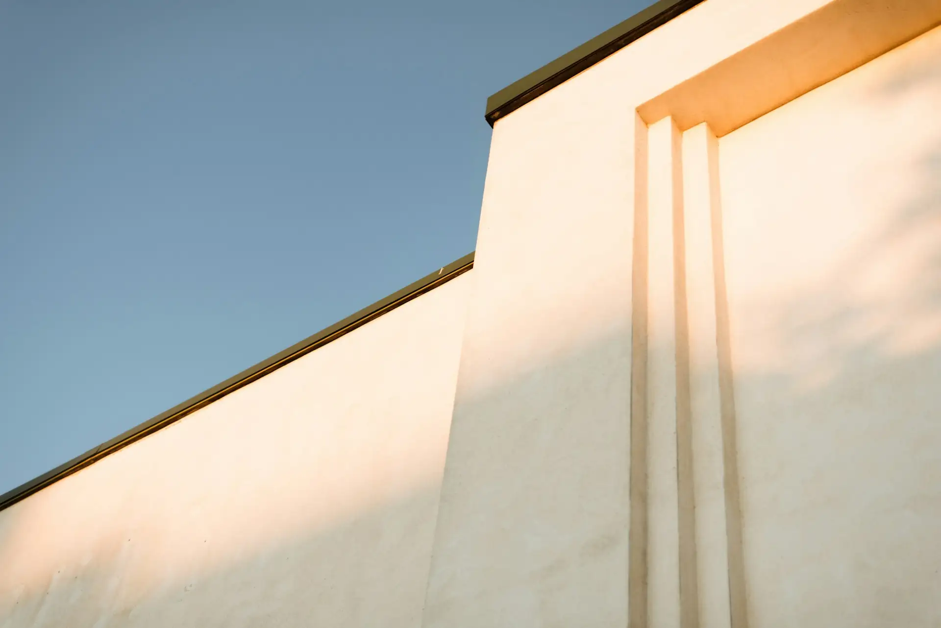 A building facade in golden evening light against a clear blue sky
